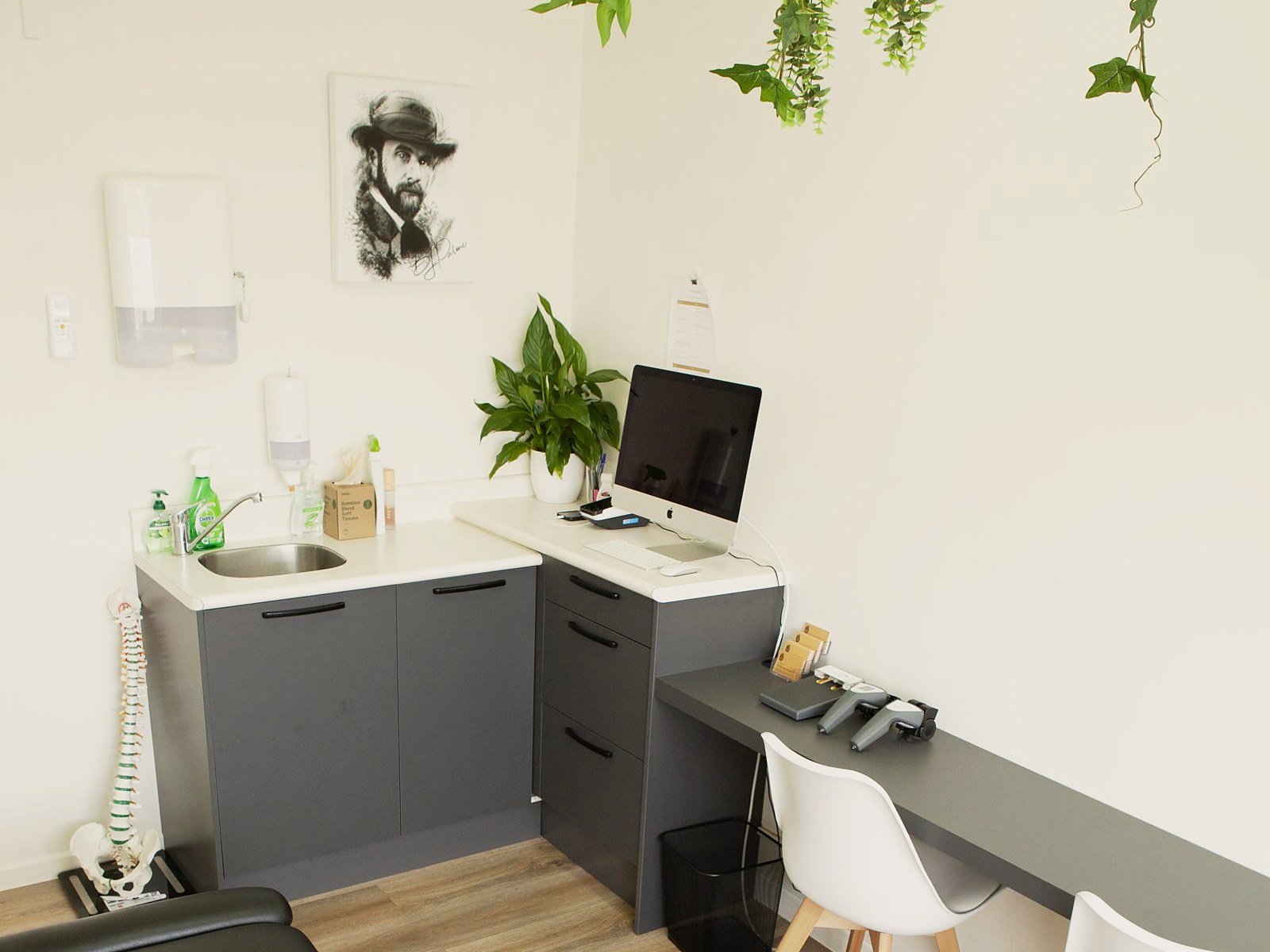 A consult room at The Healing Centre Remuera: desk, chairs and the adjusting table